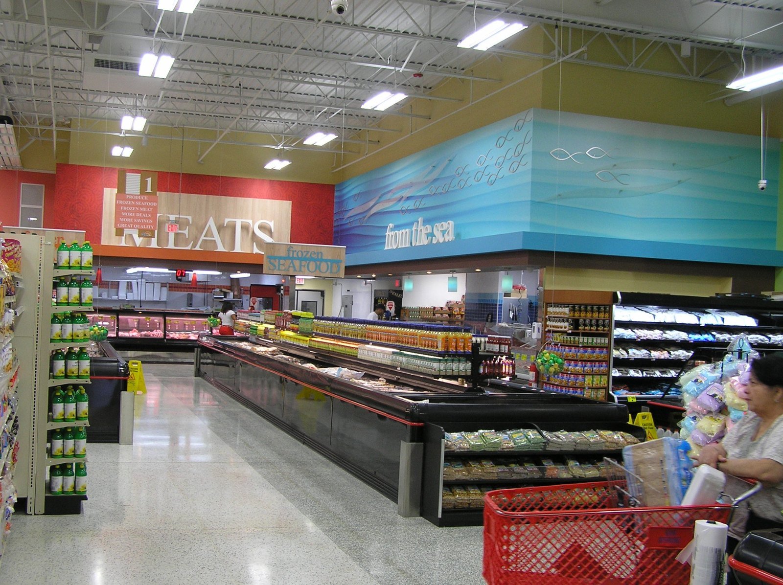 Finished supermarket interior with meat and seafood departments, overhead signage and refrigerated cases.